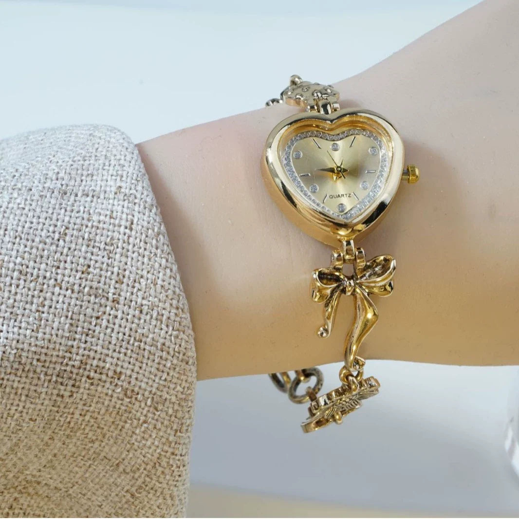 Heart Case Bracelet Watch — Gold-Tone, Crystal Bezel, Champagne Dial & Bow Charm Chain, Women